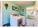 Laundry room with washer, dryer, and light teal walls at 7402 Westmoreland Dr, Sarasota, FL 34243