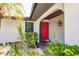 Red front door entryway with lush landscaping at 7707 10Th Nw Ave, Bradenton, FL 34209