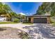 Single-story home with gray garage door, stone accents, and circular driveway at 7707 10Th Nw Ave, Bradenton, FL 34209