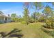 Spacious side yard with a mix of trees and grassy areas at 8139 Alan Blvd, Punta Gorda, FL 33982