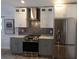 Modern kitchen with gray and white cabinets, stainless steel appliances, and marble countertops at 9641 Fulton Ave, Hudson, FL 34667