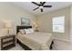 Cozy bedroom with a ceiling fan, window with blinds, and two nightstands at 1387 Still River Dr, Venice, FL 34293