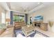 Living room with leather furniture, a ceiling fan, and a large TV at 1387 Still River Dr, Venice, FL 34293