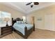Serene bedroom with tray ceiling, wood floors, and ensuite bathroom access at 1387 Still River Dr, Venice, FL 34293