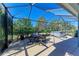 Screened-in patio with a jacuzzi, dining table, and lush landscaping at 1387 Still River Dr, Venice, FL 34293