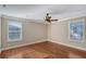 Empty bedroom with hardwood floors, white trim, and two windows letting in natural light at 1732 Hillview St, Sarasota, FL 34239