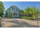 Exterior view of a two-story teal house with a driveway and tropical landscaping at 1732 Hillview St, Sarasota, FL 34239