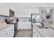 Stylish kitchen with stainless steel appliances, white cabinets, and quartz countertops, offering a sleek and modern design at 17704 Gawthrop Dr # 103, Bradenton, FL 34211