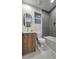 Modern bathroom with gray tile accents, sleek vanity, large framed mirror, and a combined tub and shower at 1859 Lamont St, North Port, FL 34288