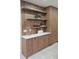Elegant kitchen features custom cabinetry, open shelving, and quartz countertops for a stylish and functional space at 1859 Lamont St, North Port, FL 34288