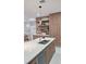 Bright, modern kitchen featuring a stainless sink, white quartz countertops, and light wood cabinets with open shelving at 1859 Lamont St, North Port, FL 34288
