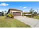 Single story house with brown garage door and lush landscaping at 208 Ariano Ave, Nokomis, FL 34275