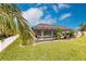 Landscaped backyard featuring a screened pool and lush greenery at 301 Gold Tree, Punta Gorda, FL 33955