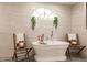 Relaxing bathroom featuring a freestanding tub, marble tile, and a large window at 301 Gold Tree, Punta Gorda, FL 33955