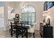 Elegant dining area with a black table, white chairs, and an arched window at 301 Gold Tree, Punta Gorda, FL 33955