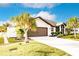 House exterior showcasing a modern garage and lush landscaping at 301 Gold Tree, Punta Gorda, FL 33955