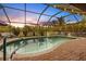 Enjoy sunsets over the pool with this screened enclosure at night at 301 Gold Tree, Punta Gorda, FL 33955