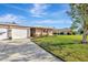 Attractive single-story home with attached two-car garage, lush green lawn, and landscaped yard at 3213 Southfield Ln # 914, Sarasota, FL 34239