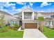 Two-story home with attached garage, balcony, manicured lawn, and beautiful landscaping at 33443 Landsman Loop, Wesley Chapel, FL 33543