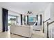Living room with sliding doors to patio, large TV, and ceiling fan at 33443 Landsman Loop, Wesley Chapel, FL 33543