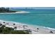 Beachfront view with umbrellas and chairs, ocean and shoreline at 415 L Ambiance Dr # F608, Longboat Key, FL 34228