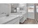 Modern bathroom featuring white double vanities, light countertops, and wood-look tile floors at 4151 Via Sienna Cir, Sarasota, FL 34243