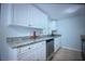 Modern kitchen featuring white cabinets and granite countertops at 4202 E Richmere St, Tampa, FL 33617