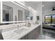 Elegant Primary bathroom with double sinks, large mirror, and a glimpse of the bedroom at 52 Audubon Pl # 52, Sarasota, FL 34237