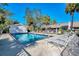 Community pool with lounge chairs and surrounding landscape at 5496 Hampstead Heath # 10, Sarasota, FL 34235