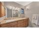 Modern bathroom with double vanity, granite countertop, and a large mirror at 5561 Golf Pointe Dr, Sarasota, FL 34243