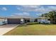 Well-maintained single-Gathering home with a two-car garage, manicured lawn, and vibrant landscaping at 6261 Keating Ave, North Port, FL 34291
