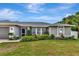 House exterior featuring gray siding, lush landscaping, and a covered entry at 6261 Keating Ave, North Port, FL 34291