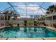 Refreshing screened pool with lush landscaping and clear water at 6261 Keating Ave, North Port, FL 34291