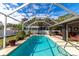 Screened pool with patio furniture and lush landscaping at 6261 Keating Ave, North Port, FL 34291