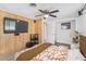 Bedroom with wood-paneled accent wall, large TV, and comfy bed at 6623 Glades Way, Sarasota, FL 34231