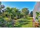Landscaped backyard showcasing tropical plants and a well-manicured lawn at 8089 Sandstar Way, Sarasota, FL 34240