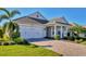 Two-story house with gray siding, a white front door and a paved driveway at 8089 Sandstar Way, Sarasota, FL 34240