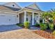 Front porch with white columns, gray siding, and a white front door at 8089 Sandstar Way, Sarasota, FL 34240