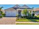 Single-story home with a white front door, two-car garage, and landscaped lawn at 8089 Sandstar Way, Sarasota, FL 34240