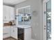 Kitchen features white cabinets, a built-in wine cooler, and a window seat at 8089 Sandstar Way, Sarasota, FL 34240
