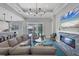 Spacious living room with a stone fireplace, sectional sofa, and large TV at 8089 Sandstar Way, Sarasota, FL 34240