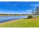 Serene waterfront view with lush green lawn and mature trees at 8544 Pavia Way, Bradenton, FL 34202