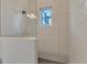 Modern shower with wave patterned tile and glass enclosure at 8544 Pavia Way, Bradenton, FL 34202