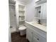 Bathroom with white vanity, wood floors, open shelving and a stand-up shower at 103 Oakwood Blvd, Sarasota, FL 34237