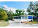 This single-story home features cream siding, a red brick foundation and a screened in porch for breezy evenings at 103 Oakwood Blvd, Sarasota, FL 34237