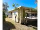 Side view showcasing carport, screened-in porch, and quaint yard for an exterior appreciation of home at 103 Oakwood Blvd, Sarasota, FL 34237