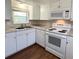 White kitchen cabinets and appliances, laminate floors at 103 Oakwood Blvd, Sarasota, FL 34237