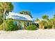 Charming cottage with metal roof, light green walls, and lush landscaping at 114 Tidy Island Blvd, Bradenton, FL 34210
