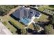 Aerial view of the home and pool, showcasing the screened lanai and lush landscaping at 13634 7Th Avenue Ne Cir, Bradenton, FL 34212