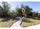 Scenic backyard with a gravel path leading to an outdoor seating area with a fire pit at 13634 7Th Avenue Ne Cir, Bradenton, FL 34212